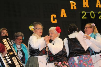 Amigas de todas las edades bailotean en el escenario.