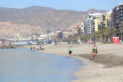 Los mayores de 70 años andando por la orilla de la playa.