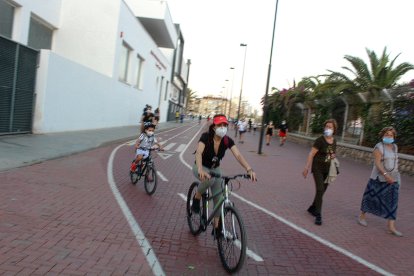 Ciclistas y con mascarilla por el carril bici del Parque de las Almadrabillas.