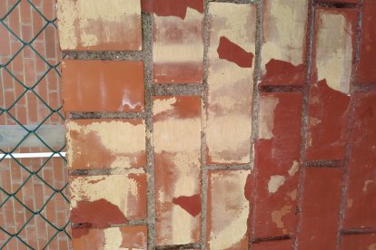 Restos de la pintada que aún reaparece en la tapia de la guardería