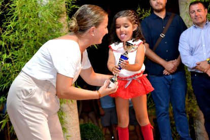 María Luisa Cruz entregando un trofeo a una joven deportisita.