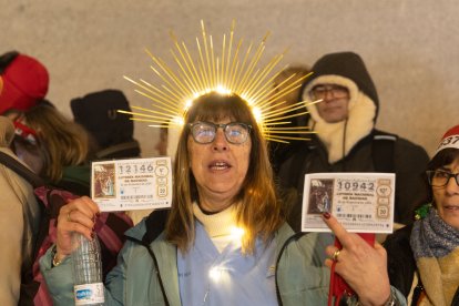 Una mujer con sus décimos hace cola antes de entrar a la celebración del Sorteo.