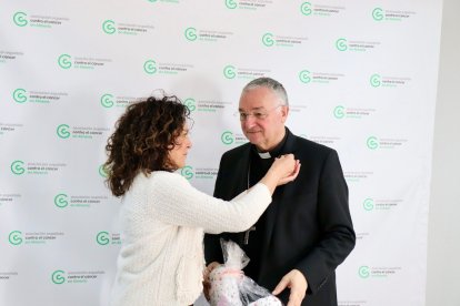 Magdalena Cantero impone la insignia de la AECC al obispo.