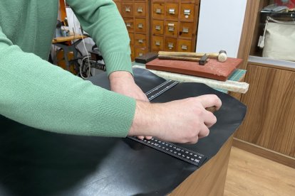 José Luis corta una pieza de cuero para un cliente.
