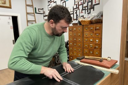 José Luis corta una pieza de cuero para un cliente.