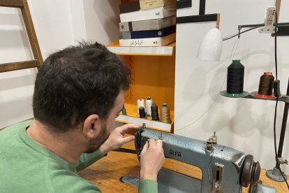 José Luis mientras cose la hebilla de un cinturón de cuero.