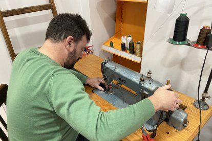 José Luis mientras cose la hebilla de un cinturón de cuero.