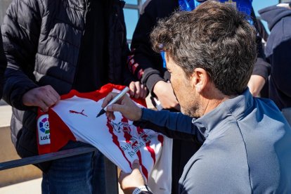 Rubi firmando una camiseta.