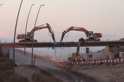 Tres máquinas demoliendo el puente.
