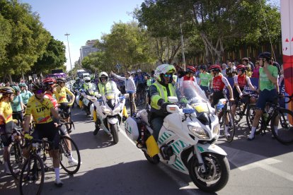 La Guardia Civil de Tráfico pasando entre las ciclistas en la salida.