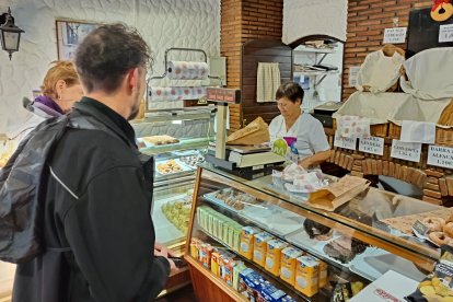 Isabel atiende a unos clientes en su negocio de panadería y dulces caseros de Calle San Miguel.