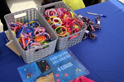 Mesa solidaria con cordones, pulseras y camisetas en la cuarta Runner Fashion.