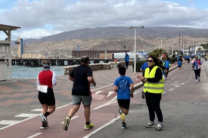 Voluntaria dando apoyo a los participantes durante la carrera solidaria.