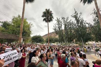 Asistentes al acto mostrando carteles en apoyo de la víctima de la agresión.