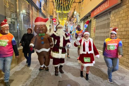 Participantes disfrazados recorren las calles del centro durante la Carrera de Navidad.