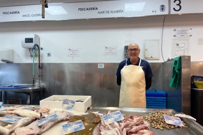 Francisco José tras el mostrador de su puesto de pescado en el Mercado Central de Almería.
