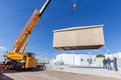 Una grua instala una de las casas construidas por la empresa almeriense.