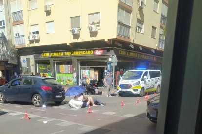Los pasajeros de la moto, tendidos en el suelo tras el accidente.