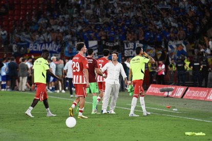 Un entrenador perdido tras la derrota levantando a sus jugadores.