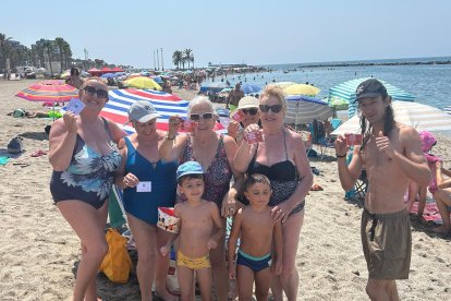 Algunas personas en la Playa Villa Antonia disfrutan de una mañana de verano y de su helado gratis.