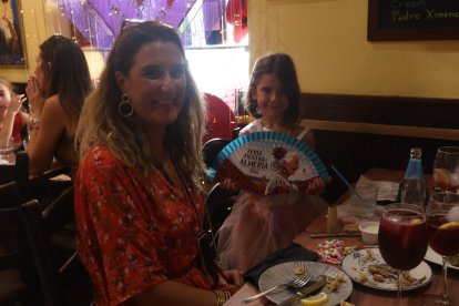 Inma Prieta e Inma Navarro, madre e hija, saborean el pascado frito de Entrefinos con su abanico de la Feria de Almería 2026.