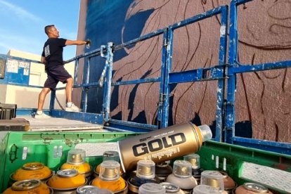 Moxaico trabajando en el mural de calle Darrical.