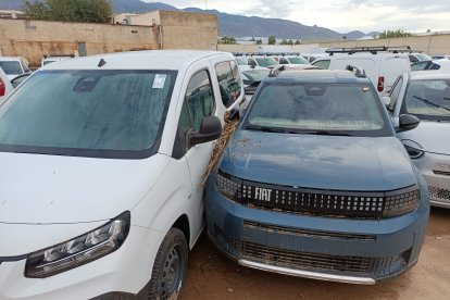Vehículos en una zona exterior que fueron arrastrados y dañados por el agua.