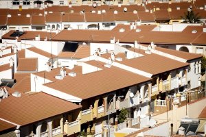 Cubiertas de dúplex con teja y claraboya que dejan pasar el sol todo el año.