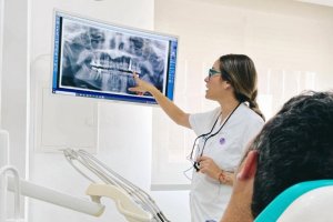 La doctora Alicia Pérez explica a un paciente su radiografía para abordar la enfermedad periodontal.