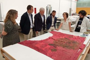 Autoridades municipales y responsables del instituto observando el Pendón Real.