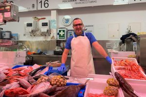 Francisco Tijeras tras el mostrador de su puesto de pescado y marisco en el Mercado Central de Almería.