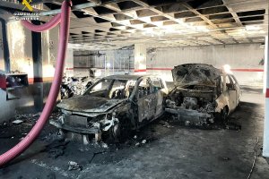 Coches calcinados en el garaje incendiado.