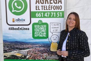 La alcaldesa de Albox junto al cartel que anuncia la iniciativa.