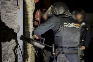 Agente de la Policía nacional golpea con un ariete la puerta de una vivienda para entrar al asalto.