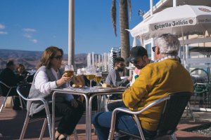 Una familia disfrutando al sol en una terraza del Paseo Marítimo de la capital almeriense.