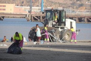 Máquinas y operarios de limpieza en la arena de las playas de la capital almeriense tras la gran Noche de San Juan.