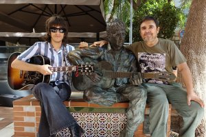 John Juárez y J. Adolfo Iglesias, junto a la estatua dedicada a John Lennon en la Plaza Flores de Almería.