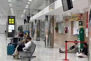 Pasajeros esperan noticias del vuelo de Almería a Madrid, que finalmente ha sido cancelado por el temporal.