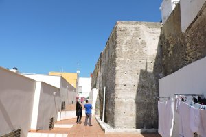 Acceso a la comunidad de viviendas en la que se encuentra integrado un torreón “quinientos años más antiguo que La Alcazaba”.