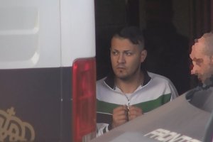El detenido sale escoltado de la Comisaría y entra en un furgón policial