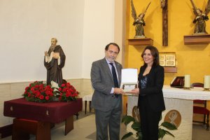 El pregonero, Juan José Melero recibe una placa de manos de la presidenta, Magdalena Cantero.