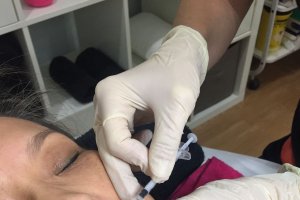 Una profesional  de FarmaEstetic aplicando bótox.