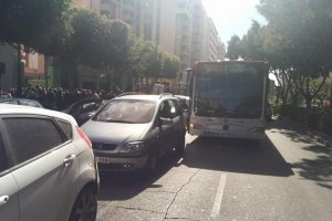 Un autobús urbano en tercera fila en una parada de La Rambla.