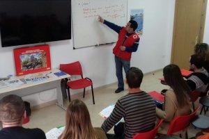 Un técnico de Cruz Roja explica a varios de los refugiados acogidos en el centro de Roquetas .