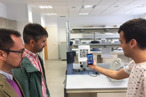 En la imagen,  uno de  participantes con la aplicación de códigos QR acompañado por los investigadores.