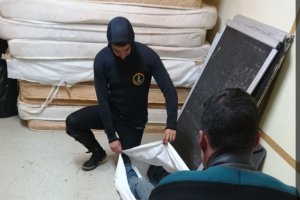 Dos efectivos de los GEAS con el cadáver de la última víctima rescatada en el naufragio.