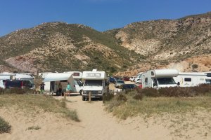Decenas de coches y autocaravanas en el Playazo de Rodalquilar, algunas de ellas con toldos y mobiliario sacados.