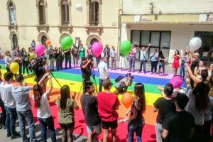 Bandera arcoíris desplegada en la Plaza de la Escuela de Artes.