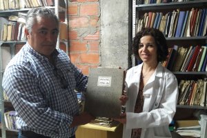 La archivera, María Lago, junto al alcalde, Jacinto Navarro, con uno de los libros más antiguos.