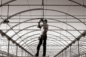 Un trabajador extranjero realiza labores de modernización de infraestructuras en un invernadero.